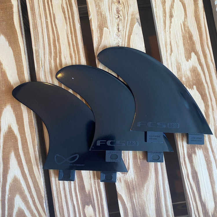 FCS 1 Thruster Set in schwarz auf Holz