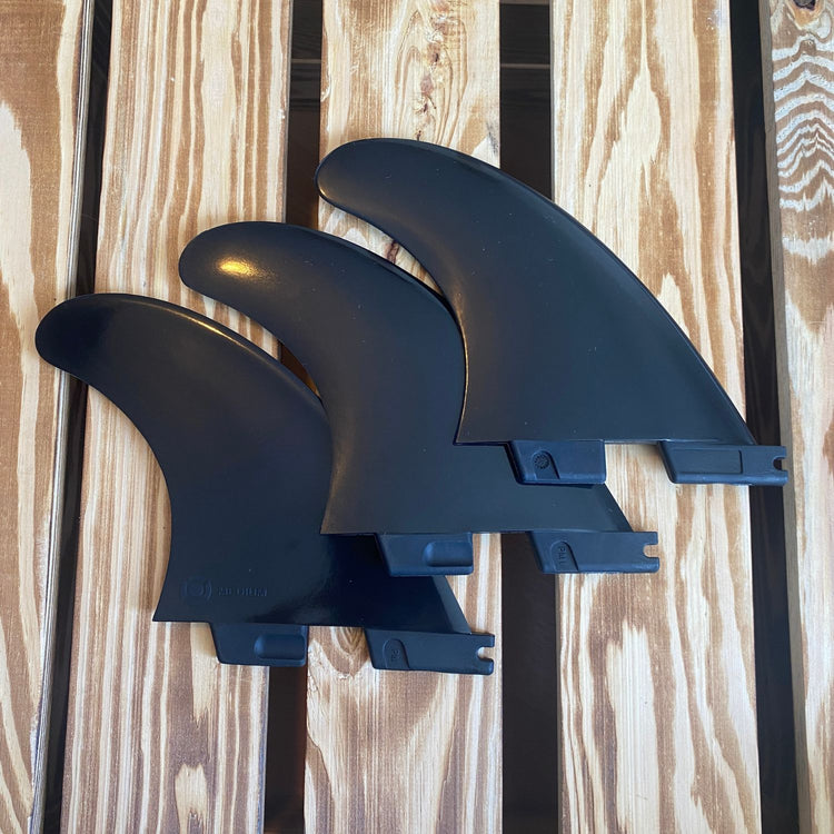 FCS 2 Thruster Set in schwarz auf Holz