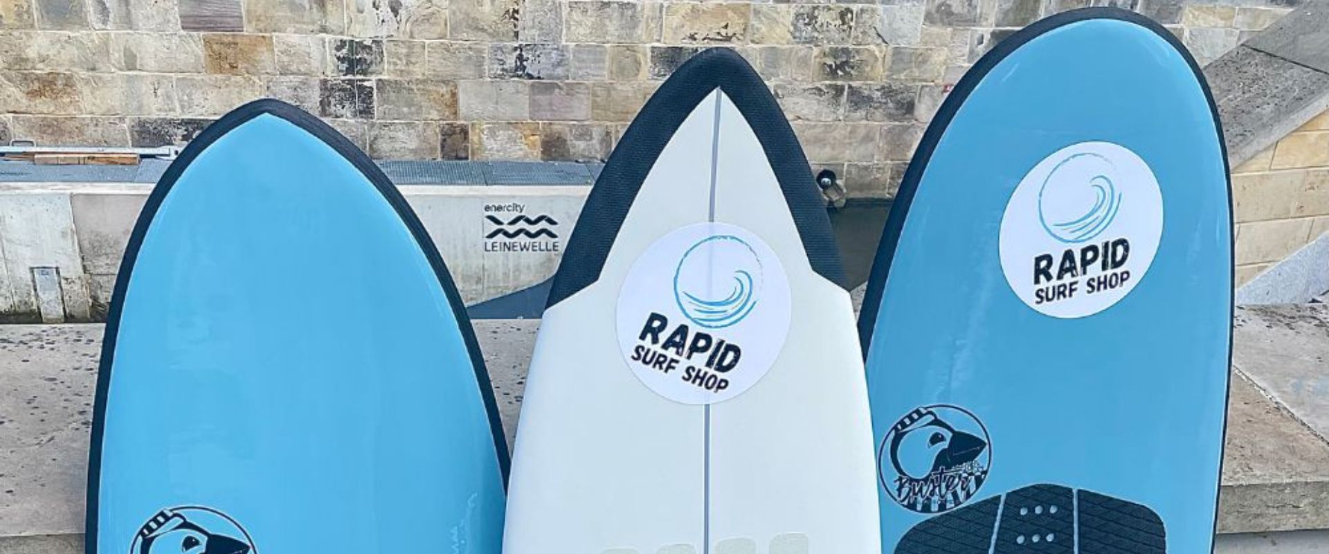 3 Spiten von Softboard Surfboards an eine Mauer gelehnt