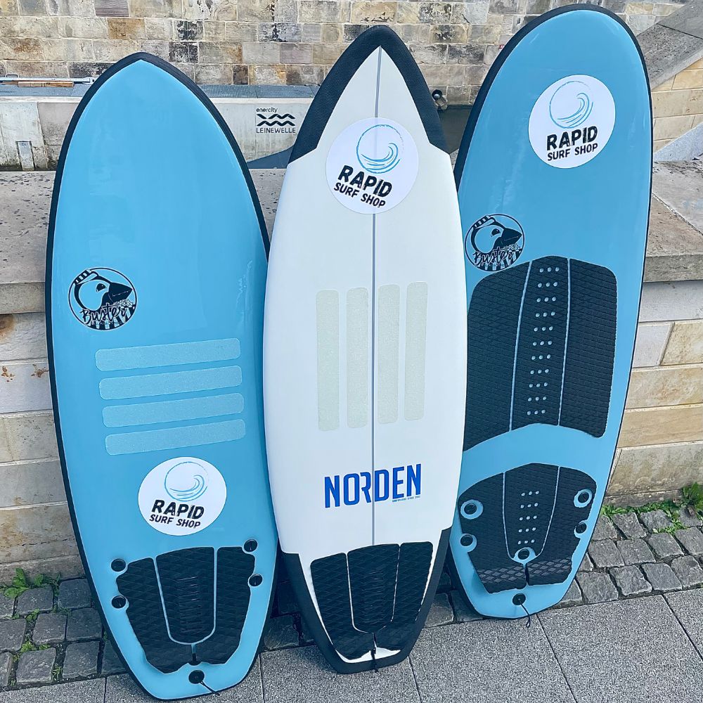 3 Softtop Surfboards stehen vor einer Mauer