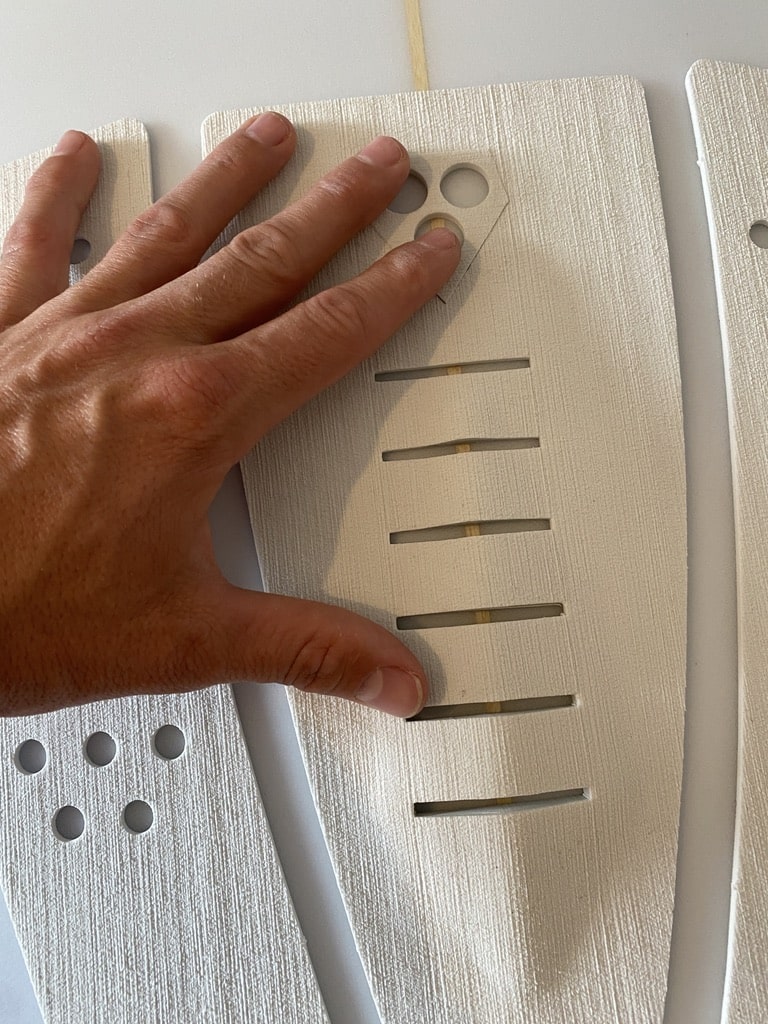 Hand die das Tailpad auf dem Surfboard festdrückt