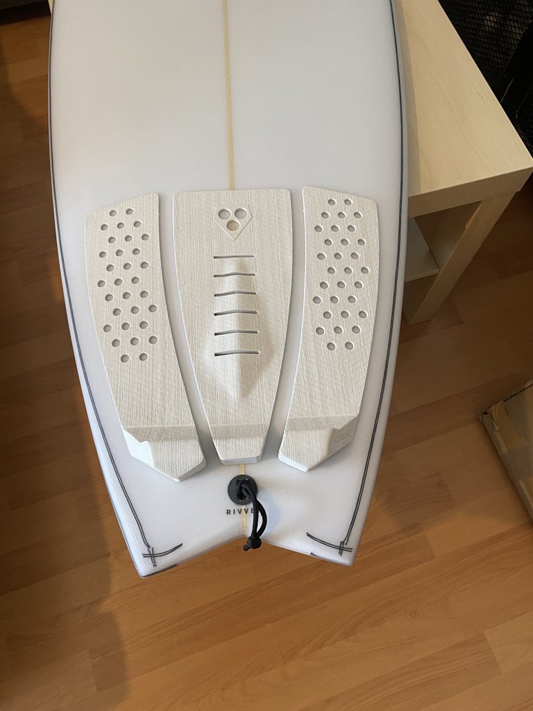 Tailpad so auf das Surfboard gelegt, dass es an die Fußbreite angepasst ist.