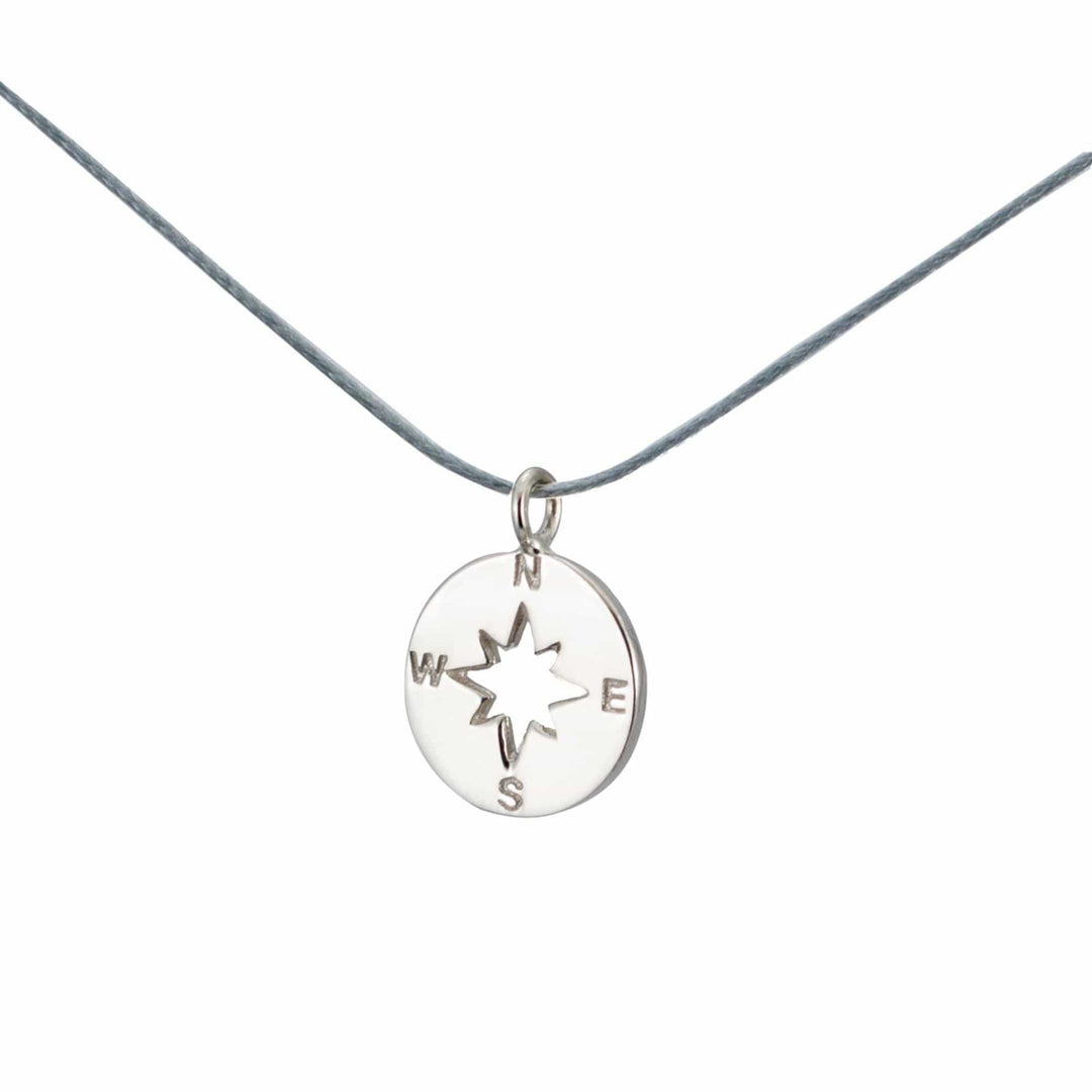 Der Silver+Surf Silber Schmuck Windrose Himmelsrichtung Anhänger aus 925 Sterling Silber mit N, E, S und W Gravur hängt an einer grauen Kordel - ein elegantes Kompass-Schmuckstück von Silver+Surf.