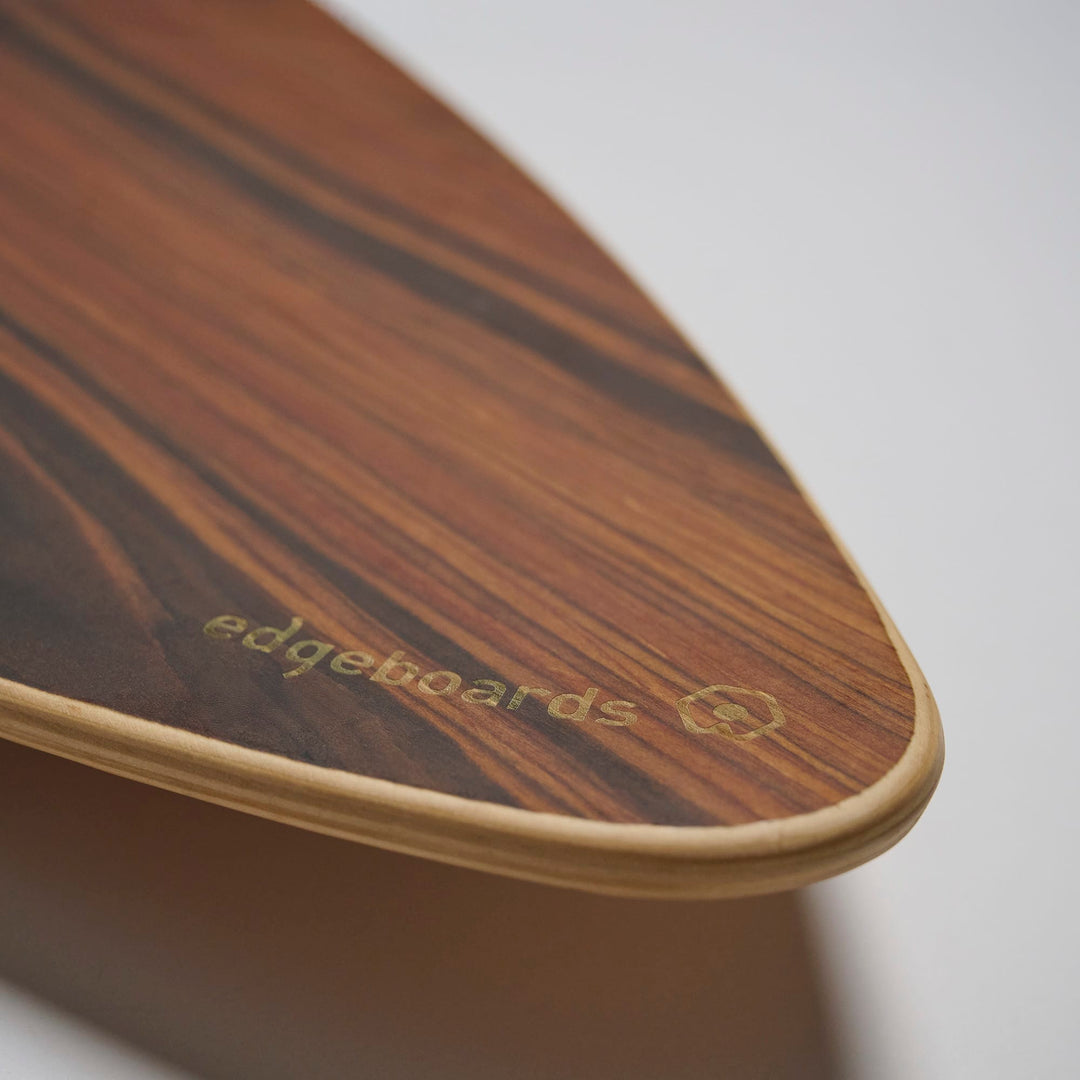 Nahaufnahme der Edgeboards Balanceboard-Spitze, die den Namen und das Logo von Edgeboards auf sichtbarer Holzmaserung trägt. Ideal für Gleichgewichtstraining oder Tricks. Einfarbiger Hintergrund.