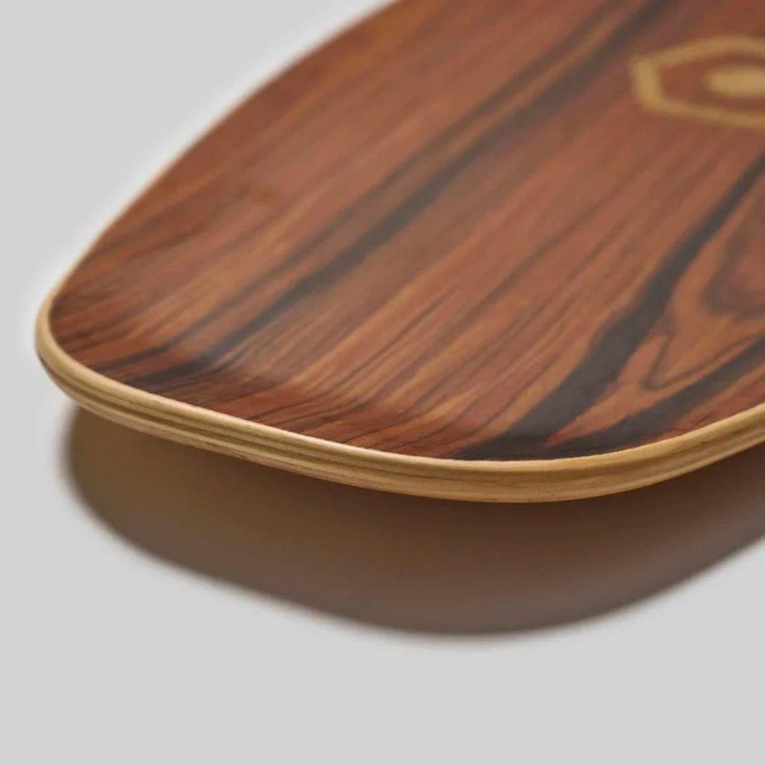 Die Nahaufnahme eines Edgeboards Balanceboards von Edgeboards zeigt die glatte, polierte Holzmaserung und die sichtbare Laminatschicht. Der schlichte hellgraue Hintergrund unterstreicht das einzigartige Design und das charakteristische Skatefeeling.
