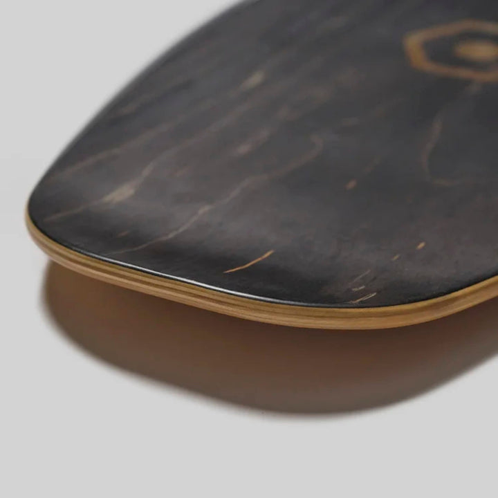 Nahaufnahme der abgerundeten Kante des Edgeboards Balanceboard von Edgeboards mit einer glatten, polierten Oberfläche aus dunklem Holz mit dezenter Maserung vor einem neutralen grauen Hintergrund - ideal für Skateboarding und Gleichgewichtstraining.