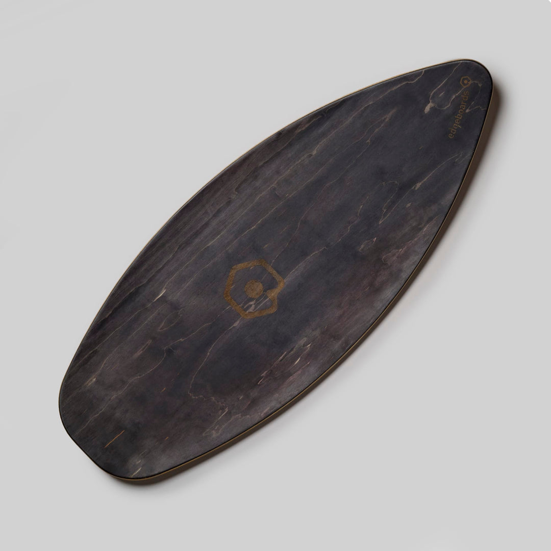 Das Edgeboards Balanceboard von Edgeboards hat ein dunkles Holzfinish, eine längliche ovale Form, ein dezentes sechseckiges Logo und glatte Kanten - ideal für Tricks und echtes Skatefeeling - auf hellgrauem Hintergrund.