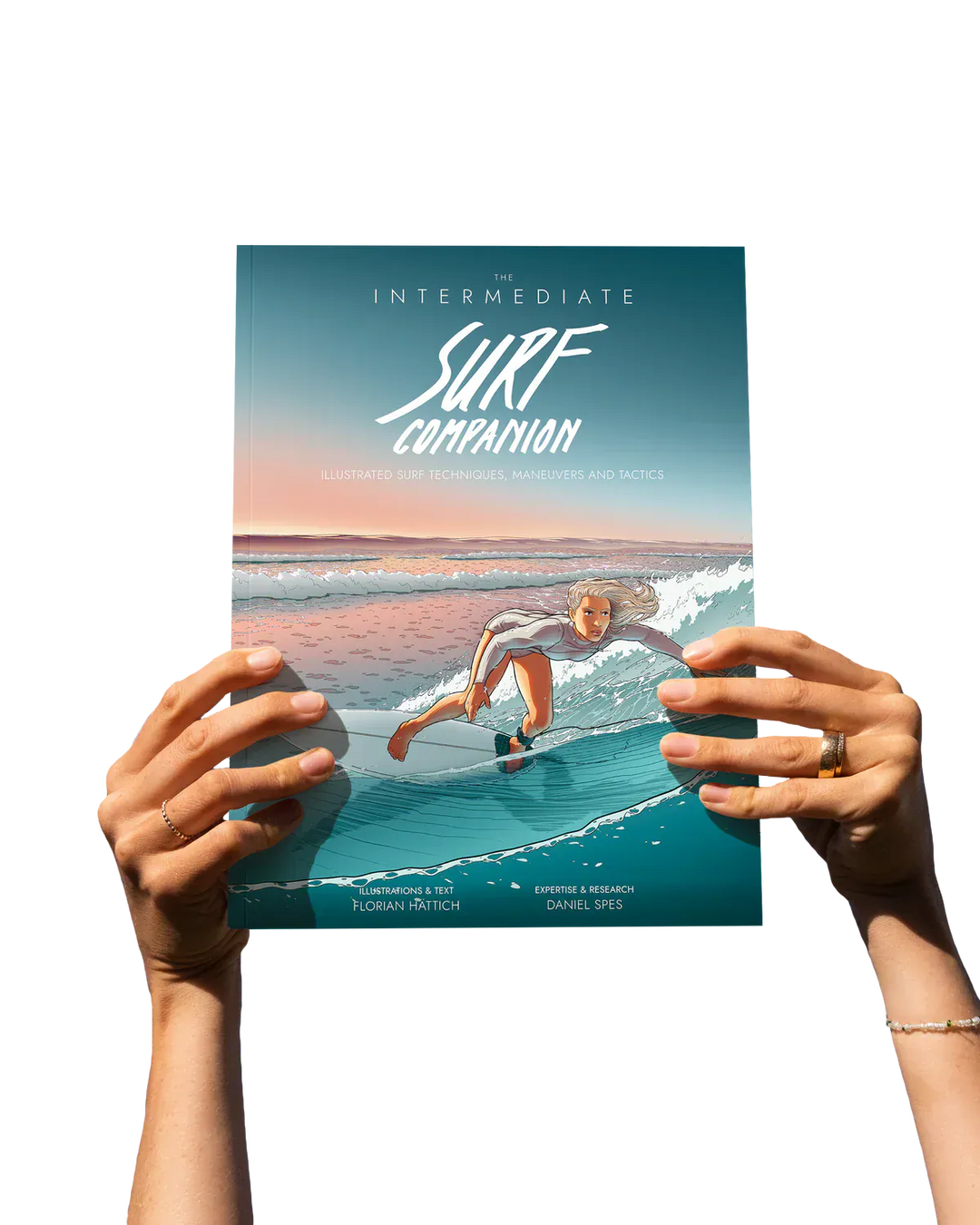 Eine Person hält den Surfcompanion Surf Companion Intermediate 4. Auflage - Surfbuch, dessen illustriertes Cover einen Surfer zeigt, der bei Sonnenuntergang auf grünen Wellen reitet, wobei nur seine Hände vor einem schlichten weißen Hintergrund zu sehen sind.