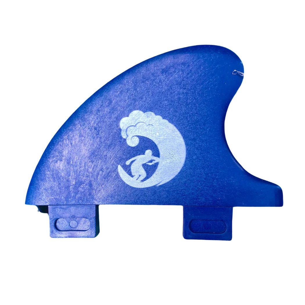 Die Rebel Fin Rebel X Driftwood - Fin Rapid Fin FCS I ist eine blaue Surfboard-Finne aus recycelten Fischernetzen mit einer weißen Surfer-Grafik vor weißem Hintergrund.
