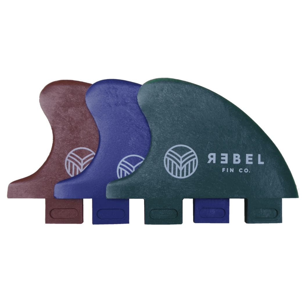 Drei Rebel Fin "Rebel X Driftwood - Fin Rapid Fin FCS I" Surfboard-Flossen in kastanienbraun, blau und grün - hergestellt aus recycelten Fischernetzen - werden überlappend dargestellt. Die grüne Finne zeigt das Rebel Fin-Logo. Jede nachhaltige Finne hat eine rechteckige Basis.