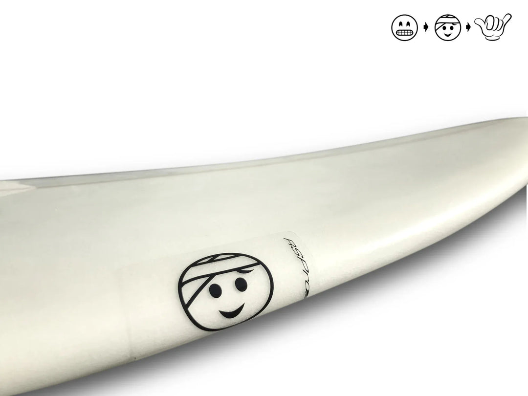 Nahaufnahme eines weißen Surfbretts mit einem schwarz umrandeten Smiley in einem Helmaufkleber in der Nähe seines Rands, mit RSPro Surfboard Ding Patches (6 Stück) von RSPro. Drei schwarz umrandete Emojis erscheinen oben rechts auf einem weißen Hintergrund.