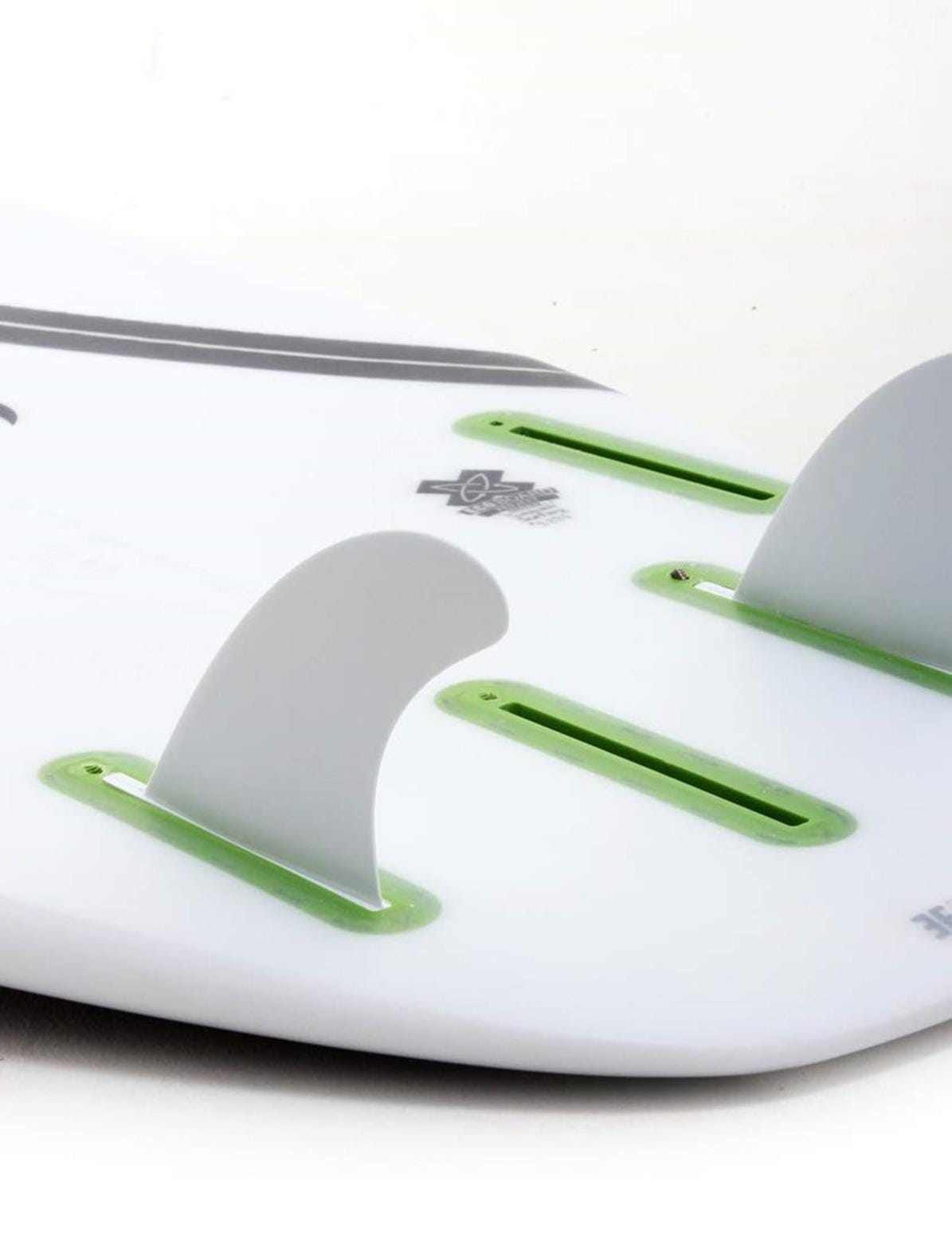 Nahaufnahme des Hecks eines weißen Surfboards, das drei Futures-Finnen in einem Thruster-Setup mit grünen Futures Truss Base-Finnenkästen und einem Teil eines Logos in der Nähe der mittleren Finne zeigt. Enthält das FUTURES Quad Rear 2 Finnen Set 3.75 Sym Thermotech.