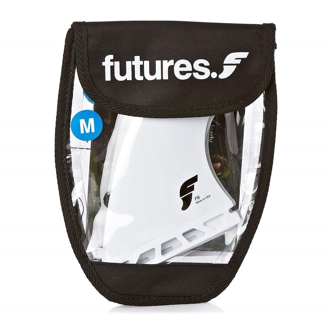 Ein durchsichtiger und schwarzer Reißverschlussbeutel mit der Aufschrift futures enthält weiße futures FUTURES Thruster Fin Set F6 Thermotech M Finnen mit einem blauen M-Größenhinweis auf der Verpackung.