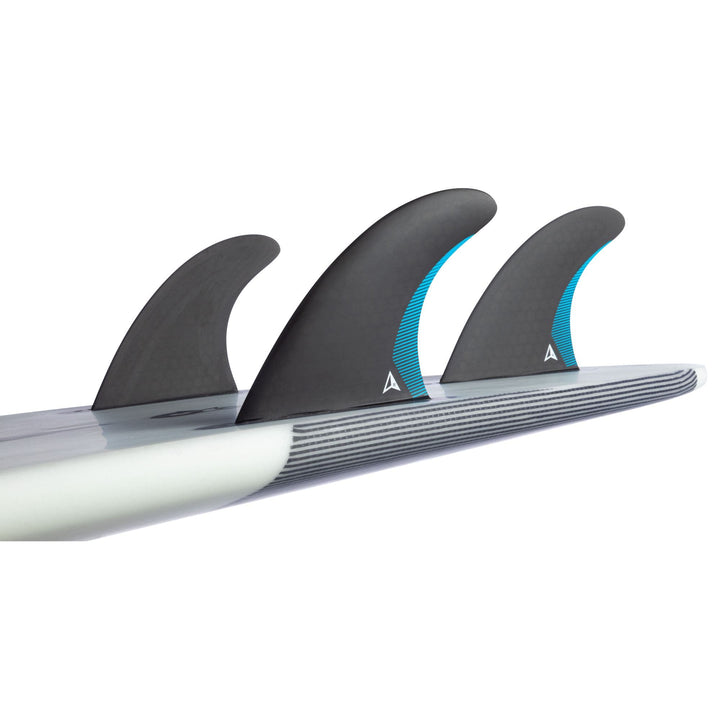 Nahaufnahme eines Performance-Shortboards mit einem Roam ROAM Thruster Fin Set Performer one tab - drei schwarze Finnen mit blauen Akzenten - an der Unterseite; das Board hat gestreifte Kanten.