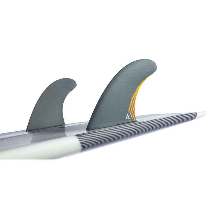 Nahaufnahme eines Surfboards mit dem Roam ROAM Twin Fin Set Medium one tab in grauer Wabe (eine Finne gelb akzentuiert), montiert auf Futures Finnenkästen. Die Marke ist Roam, und das Brett ruht auf einem schlichten weißen Hintergrund.