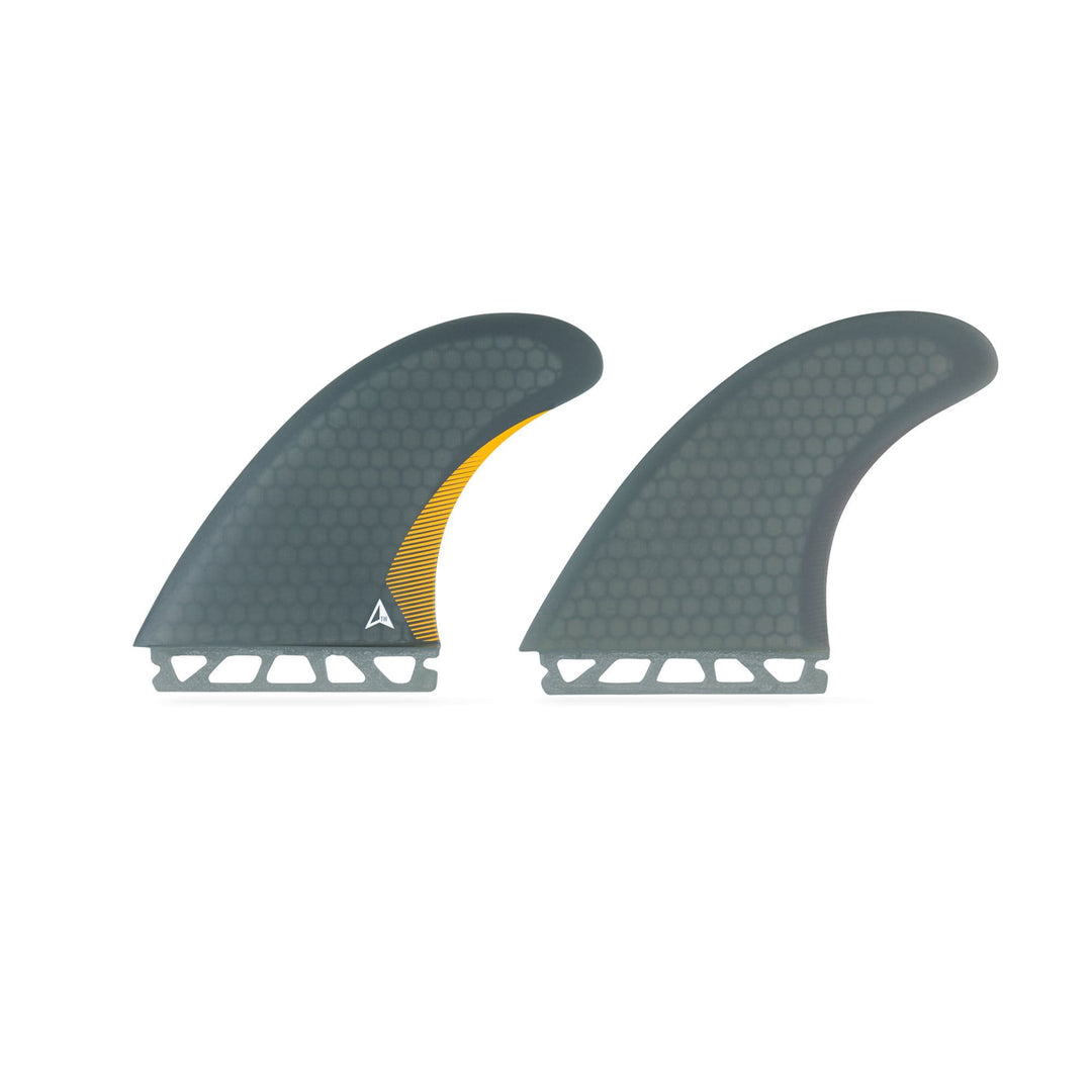 Zwei graue, wabenförmig gemusterte ROAM Twin Fin Set Medium one tab Flossen von Roam sind nebeneinander abgebildet. Die linke Flosse hat einen kleinen gelben Akzent und ein weißes dreieckiges Logo. Beide sind für das Futures Finbox System mit geschlitzten Bases konzipiert.