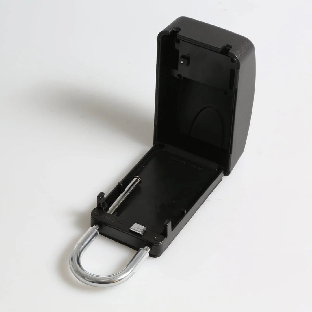 Ein schwarzes FCS - Keylock Groß/Large von FCS wird mit geöffnetem Klappdeckel gezeigt, der ein leeres Fach offenbart. Der Metallbügel ist an der Unterseite sichtbar, was es perfekt für die sichere Aufbewahrung von Autoschlüsseln macht. Einfacher weißer Hintergrund.