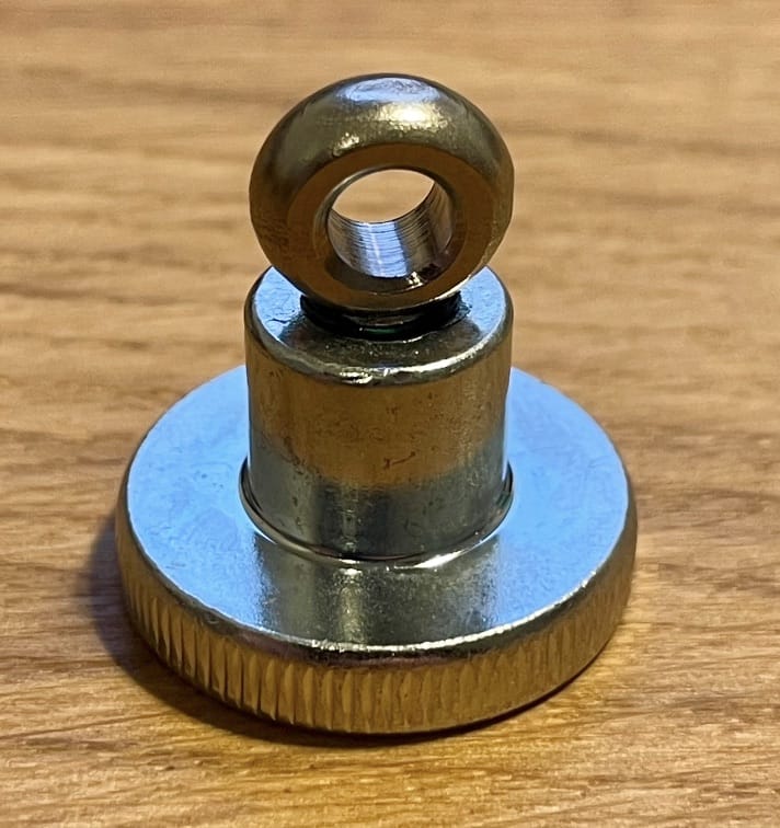 Eine Nahaufnahme des Magnet-Gegenstücks (Ersatzteil) von Rapid Surf Shop - ideal als Magnetverschluss für Ihre Leinewelle - auf einer Holzoberfläche.