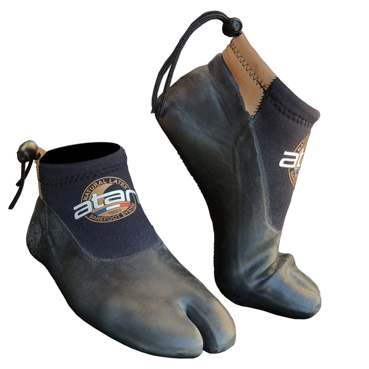 Der Atan Madi Neopren Latex Halbschuh 3mm ist ein schwarzer Wasserschuh mit geteilter Zehe, Knöchelschnüren und Barfusstechnologie für barfußähnlichen Komfort, ideal zum Windsurfen, mit atan Branding und einer strukturierten Gummisohle.