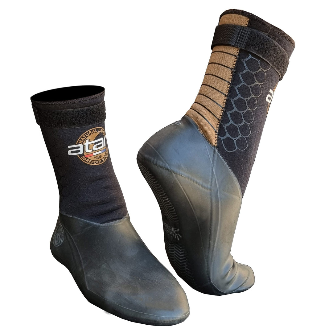 Die ATAN Mistral Neopren Latex Schuh 3mm von Atan sind schwarz-braune Wasserschuhe mit strukturierter Gummisohle und Klettverschluss, perfekt zum Windsurfen oder Kitesurfen. Das Atan-Logo befindet sich an der Seite.