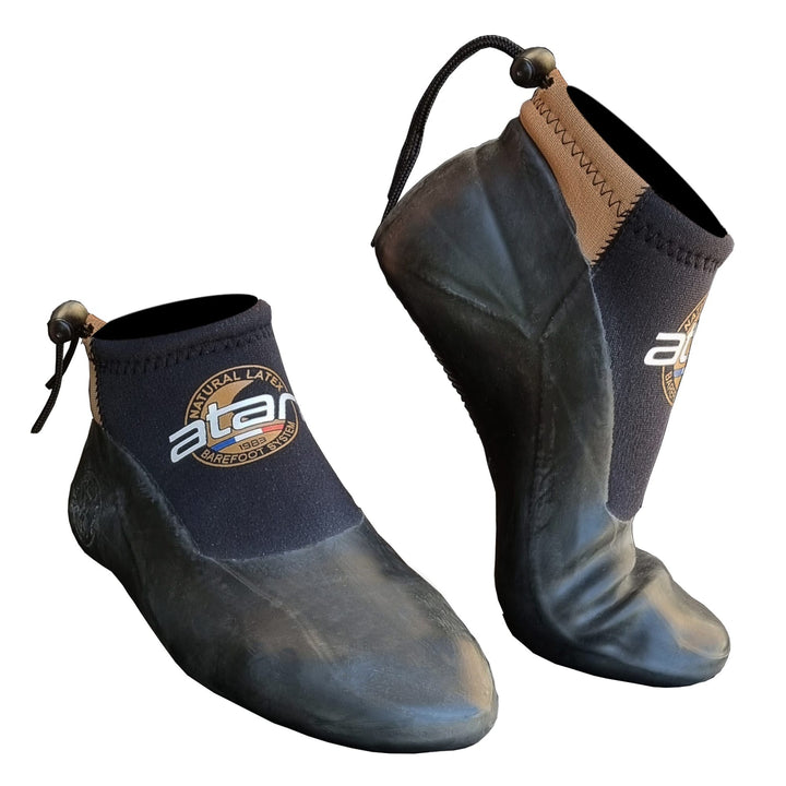 Der ATAN Sunfast Neopren Latex Schuh 3mm von Atan verfügt über schwarzes und braunes Neopren, Gummisohlen, Neopren Barfusstechnologie für ein echtes Barfußgefühl, und verstellbare Knöchelschnüre.
