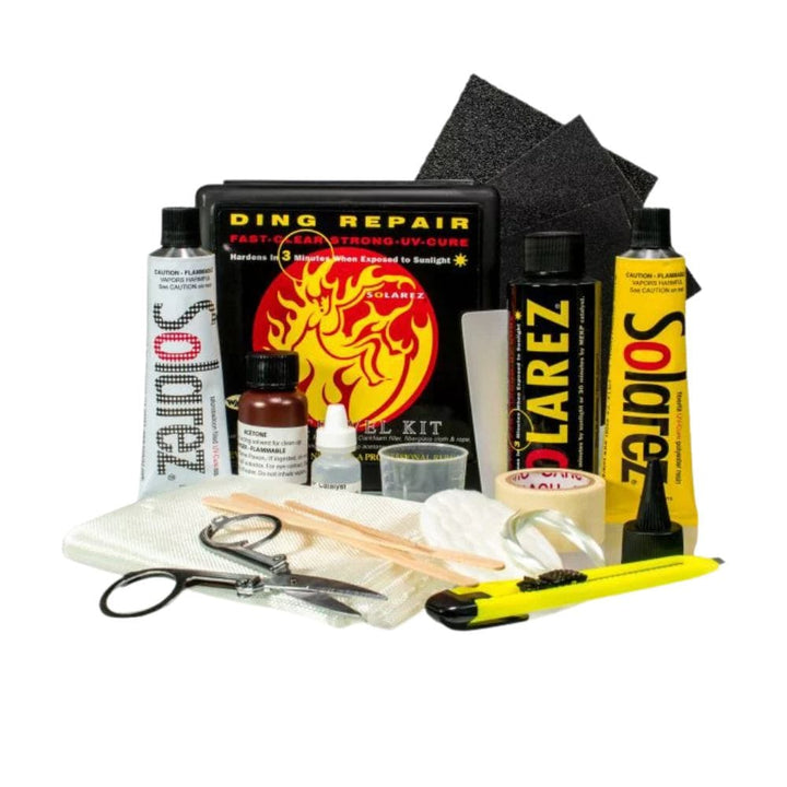 Das Solarez - Polyester Travel Repairkit Pro von Solarez enthält Harz, Sandpapier, Messer, Schere, Mischstäbchen, Gewebe, Fläschchen und Klebepatches - alles Zubehör für schnelle Surfboard-Reparaturen unterwegs.