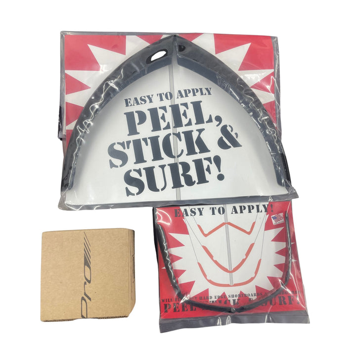 Das Rapid Surf Shop Full Surfboard Protection Bundle (groß), mit einem Traction Pad und Longboard Noseguard in einer durchsichtigen "Peel, Stick &amp; Surf!"-Verpackung, ist neben einer kleinen braunen Schachtel auf weißem Hintergrund abgebildet.