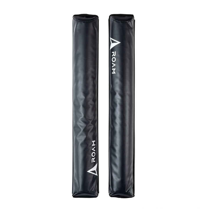 Zwei schwarze rechteckige ROAM Dachauflage Surfboard Flach Polster Pads von Roam, jeweils mit "ROAM" und einem weißen Dreieckslogo. Vertikal auf weiß abgebildet, verfügen sie über einen Klettverschluss zur einfachen Befestigung am aerodynamischen Dachträger.