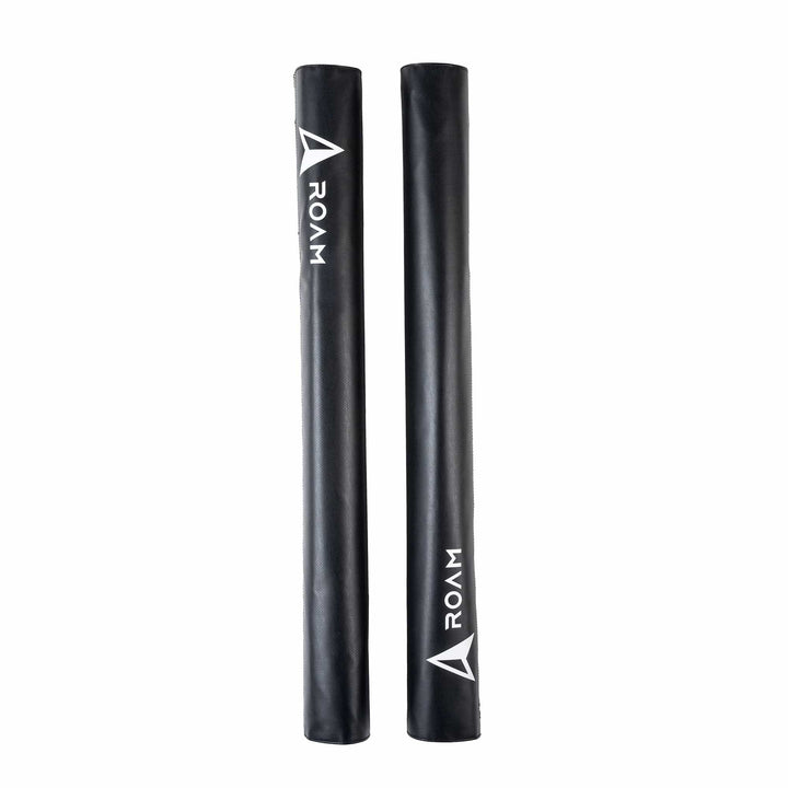 Zwei schwarze ROAM Dachauflage Surfboard Rund Polster Pads von Roam, jeweils mit dem Schriftzug "ROAM" und einem Dreieckslogo in weiß, stehen aufrecht auf weißem Grund. Die Pads verfügen über einen sicheren Klettverschluss zur einfachen Befestigung.