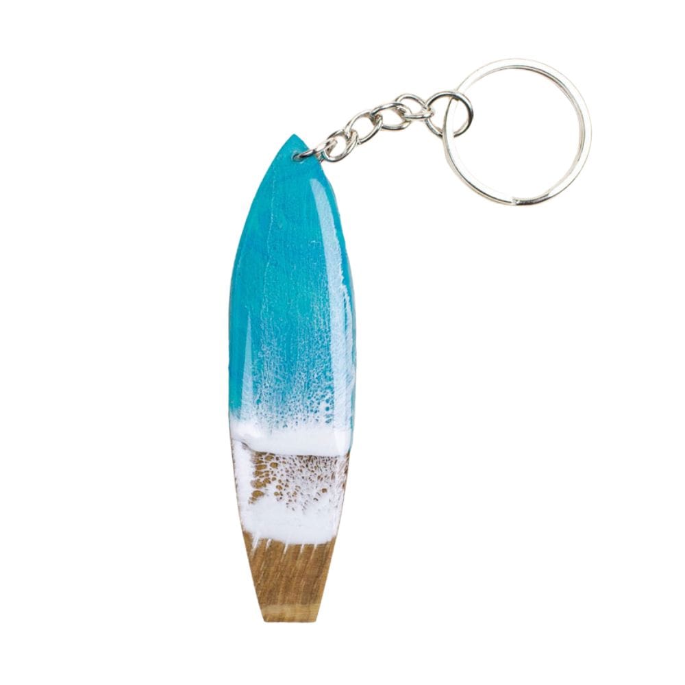 Der Surfboard Schlüsselanhänger handgefertigt von Takemetotheocean besteht aus einem kleinen surfbrettförmigen Anhänger in Blau, Weiß und Naturholz mit Resin Ocean Art, befestigt an einer Metallkette mit Schlüsselring.