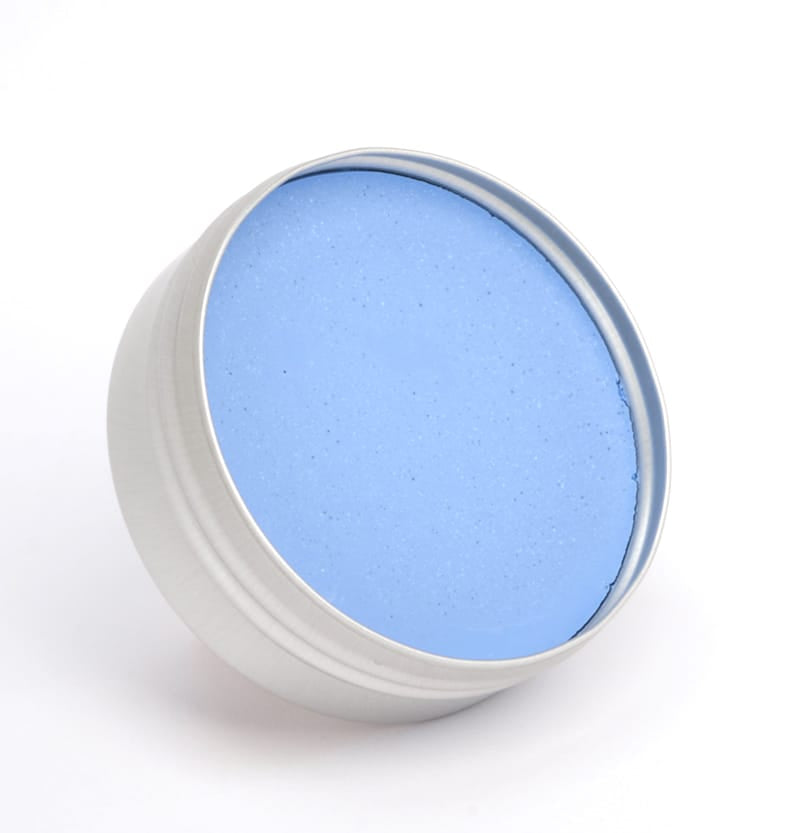 Eine runde, offene Metalldose, gefüllt mit glattem, kräftigem blauem It&