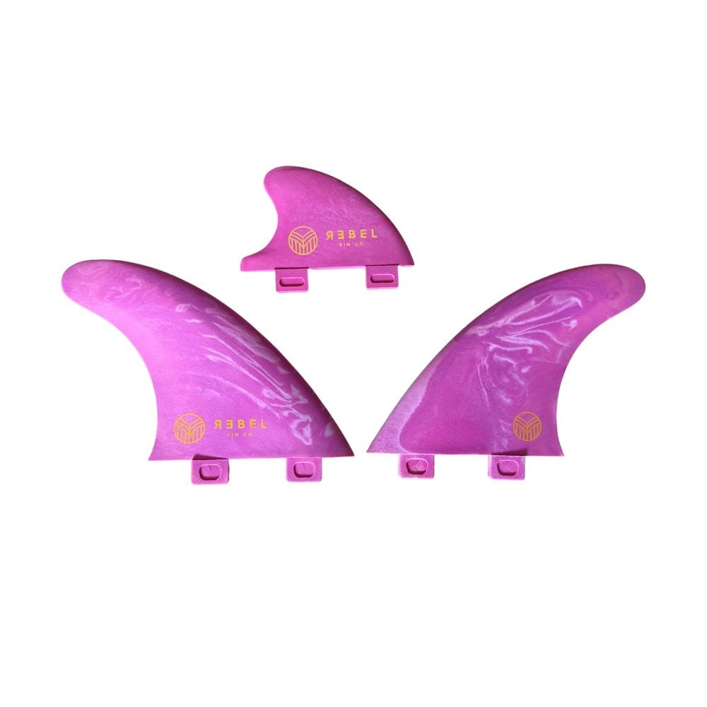 Drei recycelte Flossen aus rosa Marmor aus dem Rebel Fin - Rapid Fin Set FCS I (von Rebel Fin), jeweils mit goldenen Logos, sind auf einem weißen Hintergrund angeordnet. Das Set besteht aus zwei großen Flossen und einer kleineren Mittelflosse, die alle mit Laschen für das Surfen im Fluss ausgestattet sind.