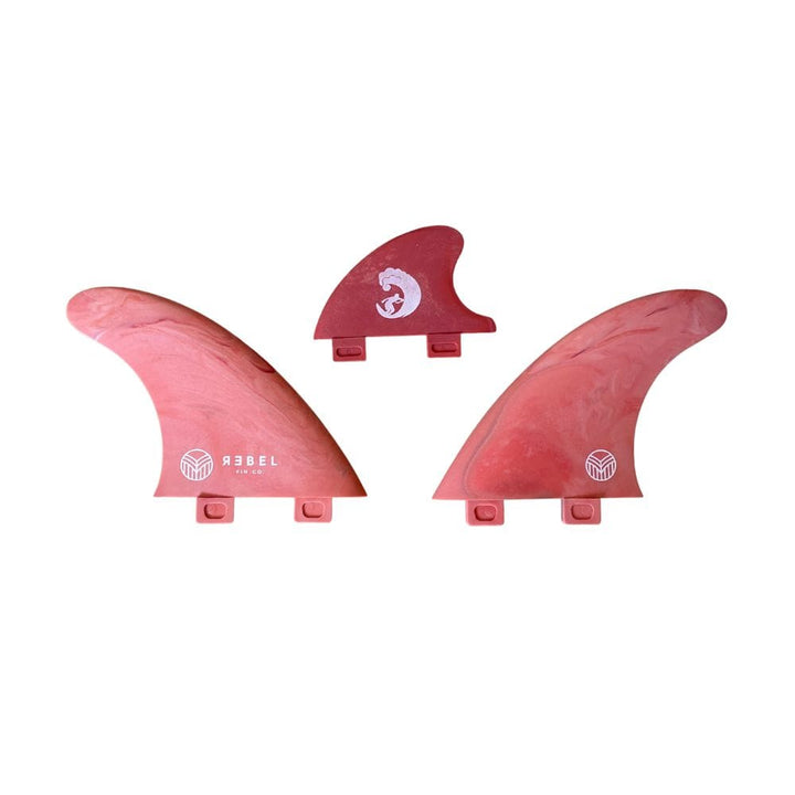 Drei Rebel Fin - Rapid Fin Set FCS I - Marble Surfboard Finnen in rotem Marmor, gebrandet von Rebel Fin, werden nebeneinander ausgestellt. Jede Finne verfügt über Befestigungslaschen und ein weißes Logo, perfekt für Fluss-Surfen.