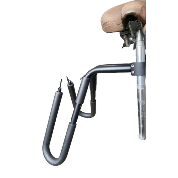 Eine Nahaufnahme des Rapid Surf Shop Surfboard Bikerack, ein schwarzer U-förmiger Metallträger mit zwei gepolsterten Armen und sichtbaren Befestigungselementen, der an der Sattelstütze eines Fahrrads mit braunem Sattel befestigt ist.