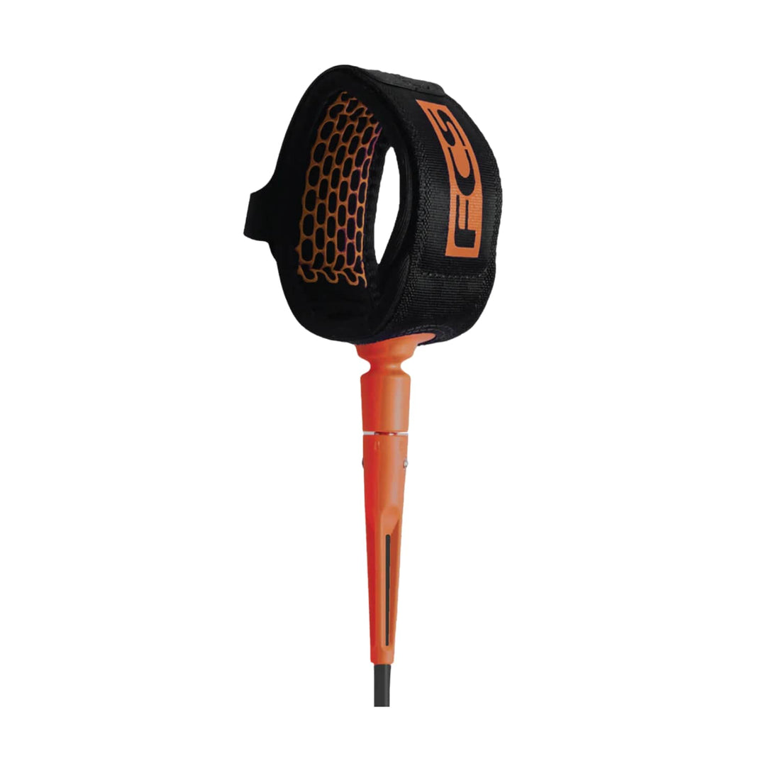 Die FCS Comp Essential Leash 5ft hat eine schwarz-orangefarbene Manschette mit einem sechseckigen Muster, FCS-Branding auf dem Gurt und einen orangefarbenen Kordelstecker - ideal zum Sichern des Surfbretts beim Surfen im Meer oder auf dem Fluss.