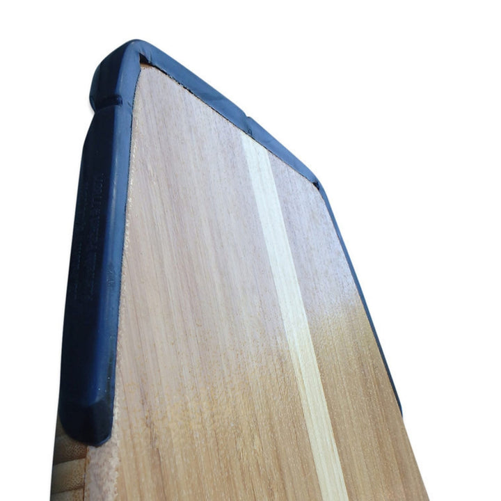 Nahaufnahme der Ecke eines rechteckigen Holzschneidebretts mit einem hellen Streifen, der an den Kanten mit SurfCo Hawaii - Jumbo Tailguard Schutzhüllen von SurfCo Hawaii versehen ist.