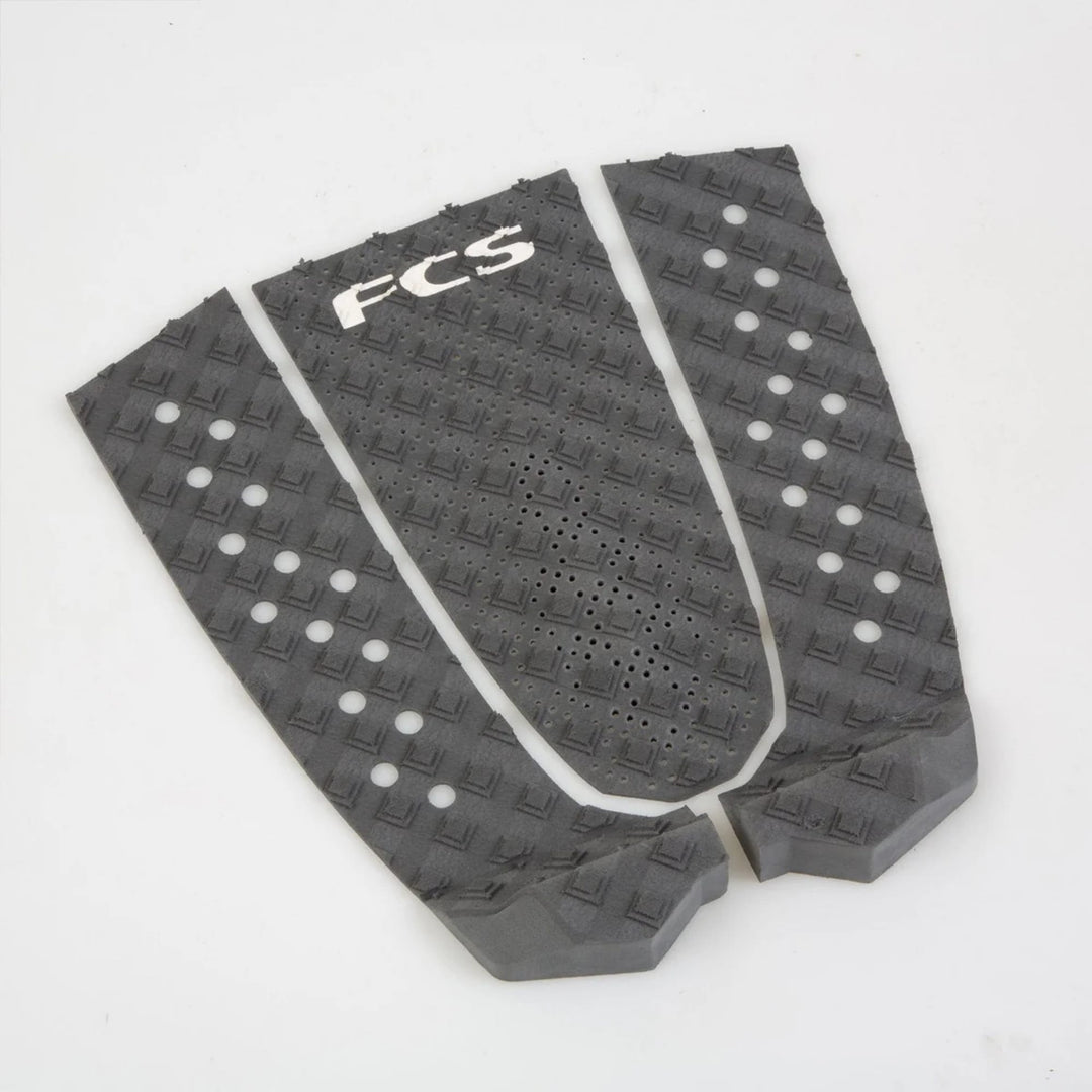 Drei schwarze FCS T-3 Eco Eclipse Tailpads von FCS, hergestellt aus nachhaltigem Surfboard-Tailpad-Material und Zuckerrohr-Schaum, verfügen über einen strukturierten Diamantgriff und kreisförmige Aussparungen für umweltfreundliche Traktion.