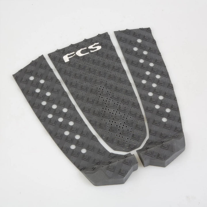 Drei schwarze FCS T-3 Eco Eclipse Tailpads von FCS, hergestellt aus nachhaltigem Surfboard-Tailpad-Material und Zuckerrohr-Schaum, verfügen über einen strukturierten Diamantgriff und kreisförmige Aussparungen für umweltfreundliche Traktion.