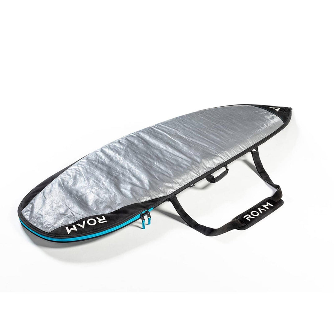 Die ROAM Boardbag Surfboard Daylight Shortboard hat ein gepolstertes silbernes Äußeres, schwarze Verzierungen, einen blauen Reißverschluss und schwarze Griffe mit dem Aufdruck "ROAM" in Weiß. Auf dem Bild ist die Tasche teilweise geöffnet.