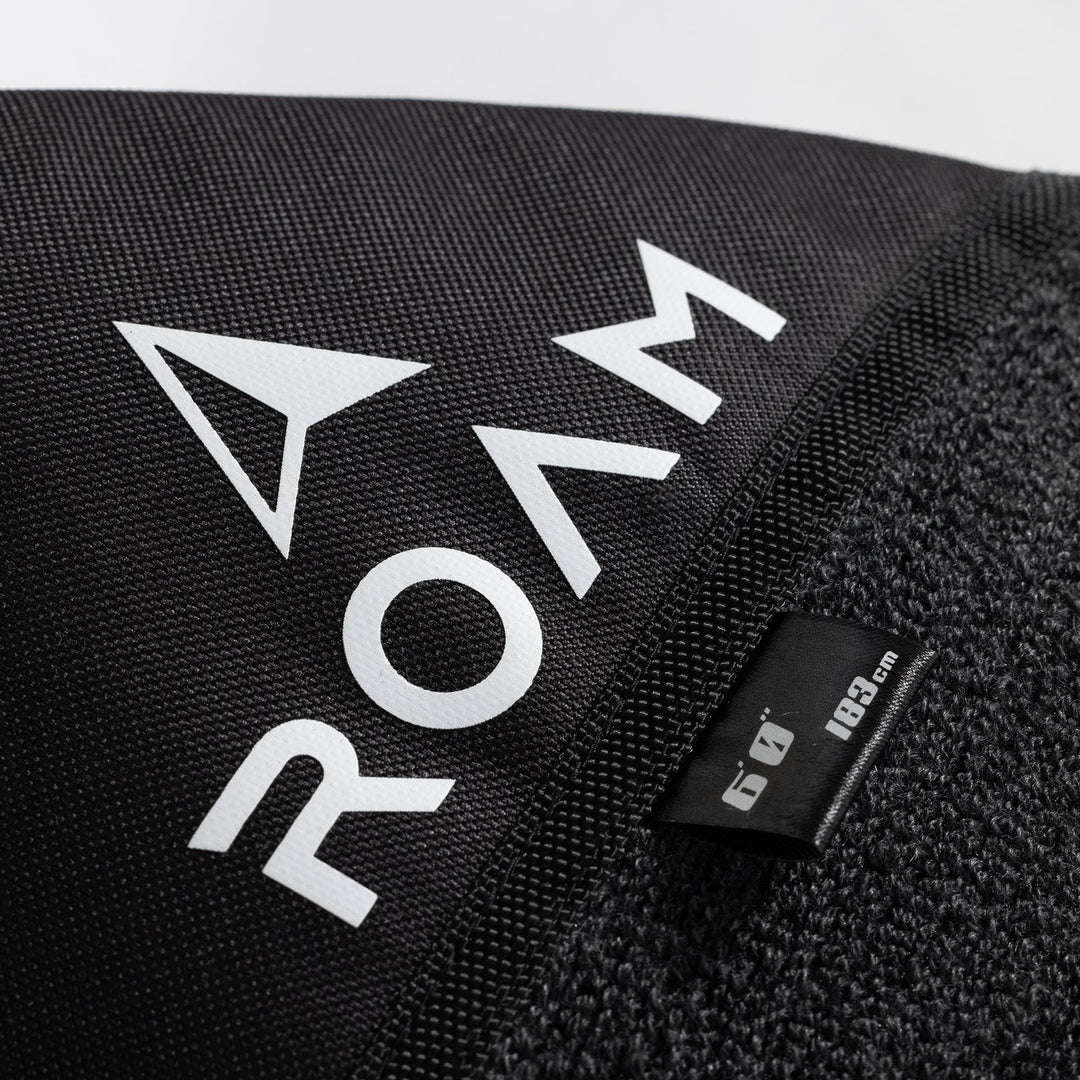 Nahaufnahme der schwarzen ROAM Surfboard Socke ECO Hybrid Fish von Roam, mit auffälligem weißem ROAM-Schriftzug und einem 184 cm langen Schild. Der Stoff kombiniert glatte und strukturierte Bereiche für einen stilvollen, umweltfreundlichen Schutz für dein Board.
