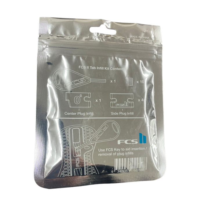 Eine silberne, wiederverschließbare Verpackung mit der Aufschrift FCS - Tab Infill Kit by FCS enthält 1 Mittelstöpselfüllung, 4 Seitenstöpselfüllungen und 10 Schrauben - perfekt für die Anpassung von FCS I Flossen an FCS II Flossenkästen. Auf der Vorderseite sind die einzelnen Artikel mit einfachen Strichen abgebildet.