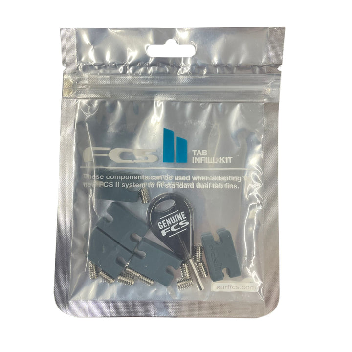 Das FCS - Tab Infill Kit von FCS kommt in einem versiegelten, durchsichtigen Beutel mit grauen Kunststoffteilen, Schrauben und einem schwarzen Werkzeug - perfekt für die Verwendung von FCS II Finboxen oder die Anpassung von FCS I Flossen. Weißes Branding und Text erscheinen auf der Vorderseite.