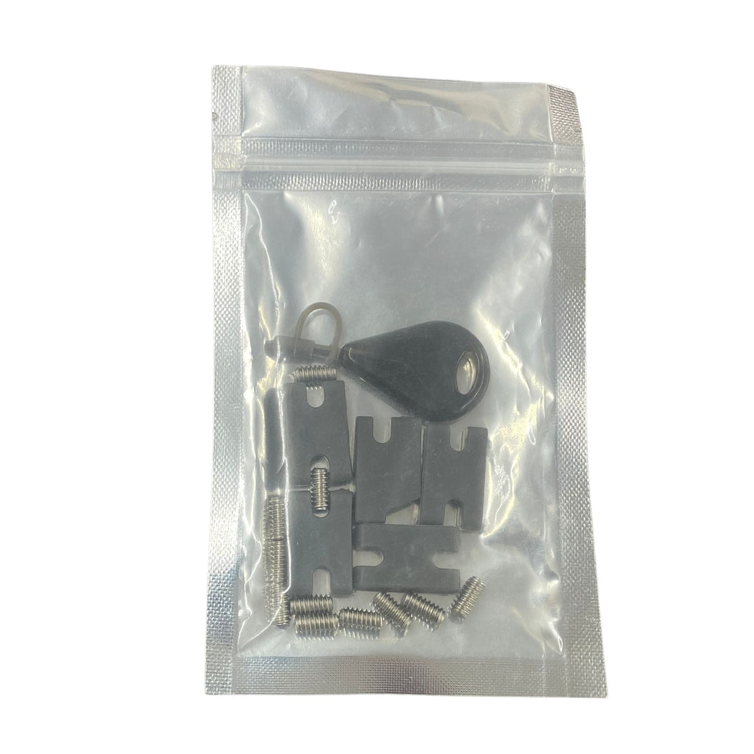 Eine versiegelte, durchsichtige Plastiktüte von Rapid Surf Shop enthält ein Tab Infill Kit mit einem schwarzen, schlüsselförmigen Werkzeug, flachen, gekerbten Metallteilen, Metallspulen und einem runden Metallring, die alle auf einem weißen Hintergrund abgebildet sind.